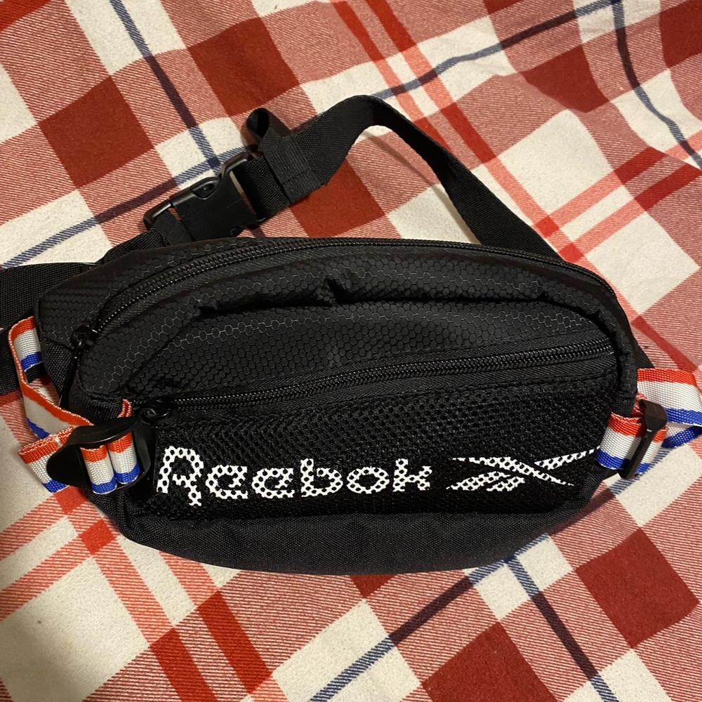 Black Reebok Fanny pack with red white and blue strap across front